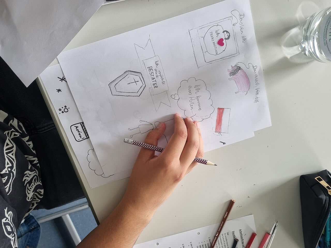Eine Schülerin gestaltet mit Bleistift und Buntstiften einen persönlichen Steckbrief mit Zeichnungen und kurzen Texten.