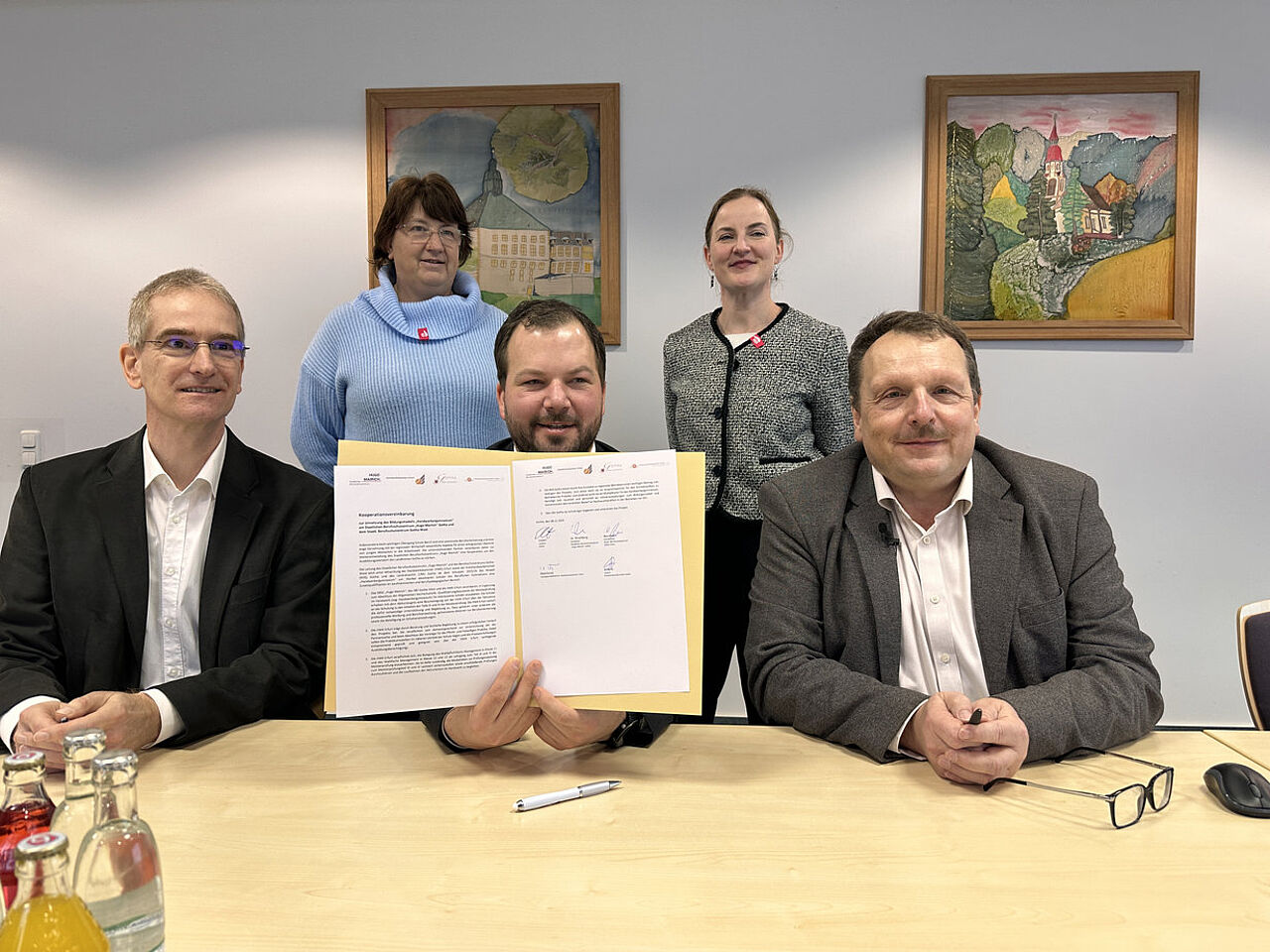 Vertreterinnen und Vertreter der beteiligten Bildungseinrichtungen präsentieren die unterzeichnete Kooperationsvereinbarung für das Handwerkergymnasium.