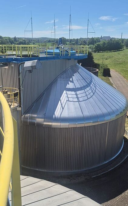 Blick von einer erhöhten Plattform auf einen metallverkleideten Rundbehälter und die Umgebung von Gotha.