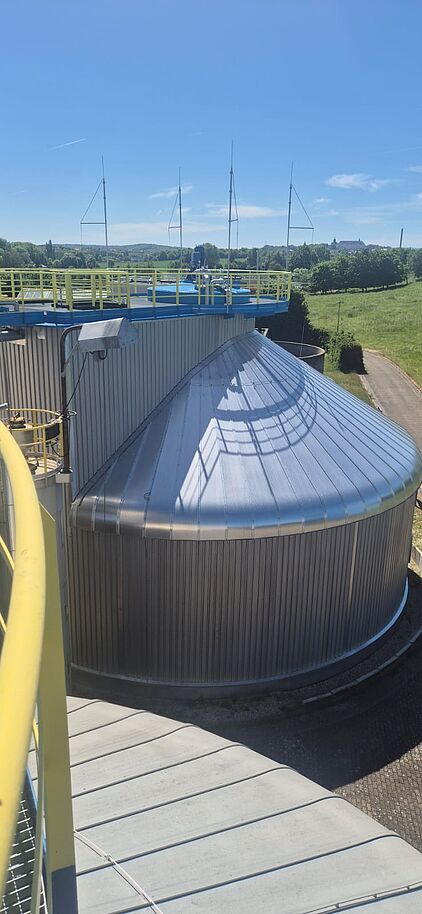 Blick von einer erhöhten Plattform auf einen metallverkleideten Rundbehälter und die Umgebung von Gotha.